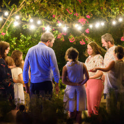 family outdoor party illuminated by lights