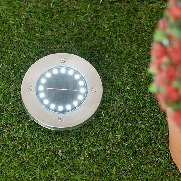 Solar deck light installed in a garden.