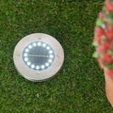 Solar deck light installed in a garden.