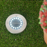 Solar deck light installed in a garden.