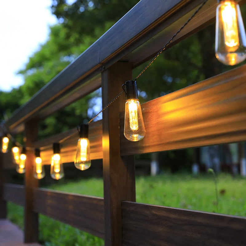 warm white solar festoon lights hung on yard fence